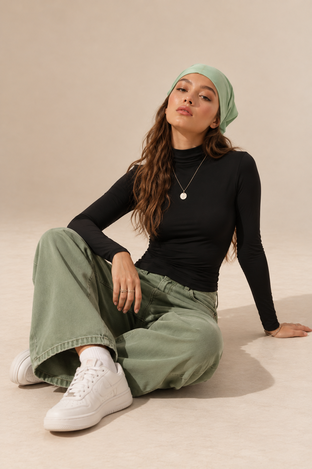 Elara women's black long-sleeve roll neck top, shown in a seated front view.