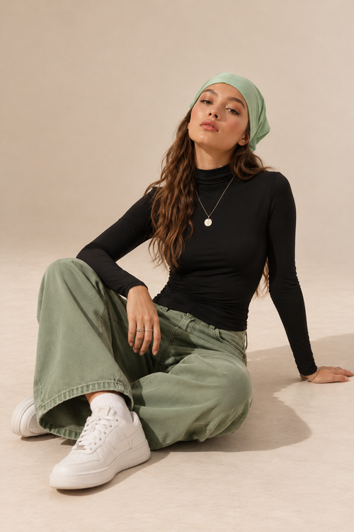 Elara women's black long-sleeve roll neck top, shown in a seated front view.