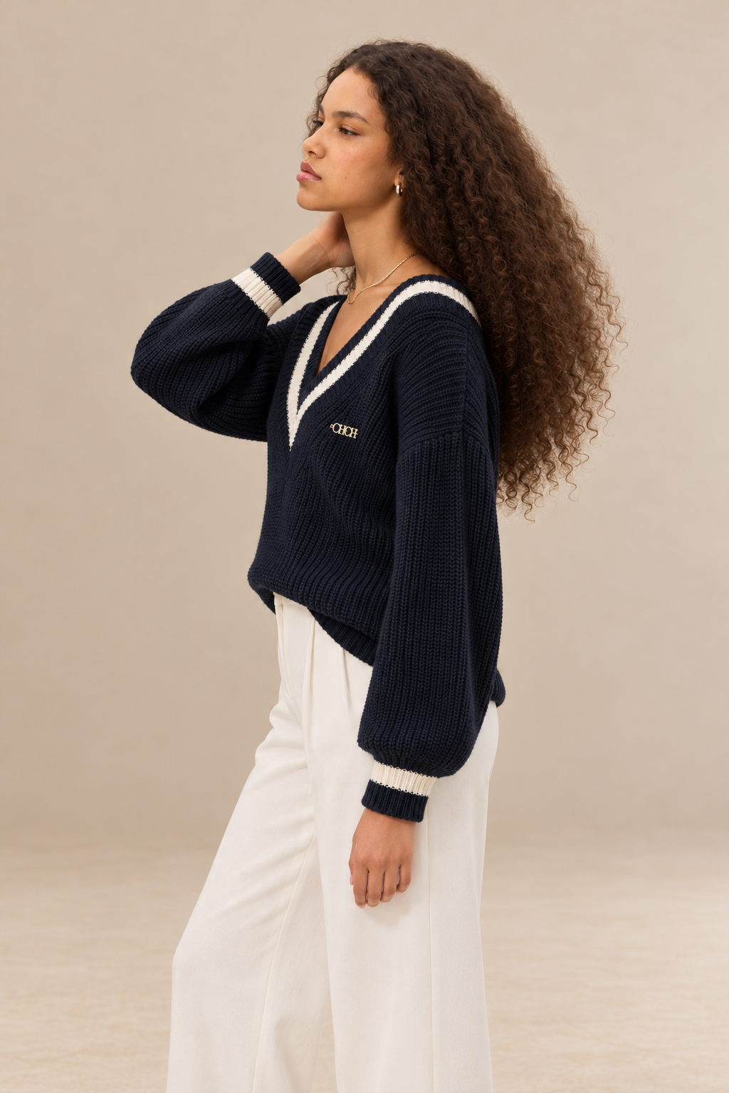 Margot women's navy blue knitted V neck jumper with cream contrast stripes — side view.