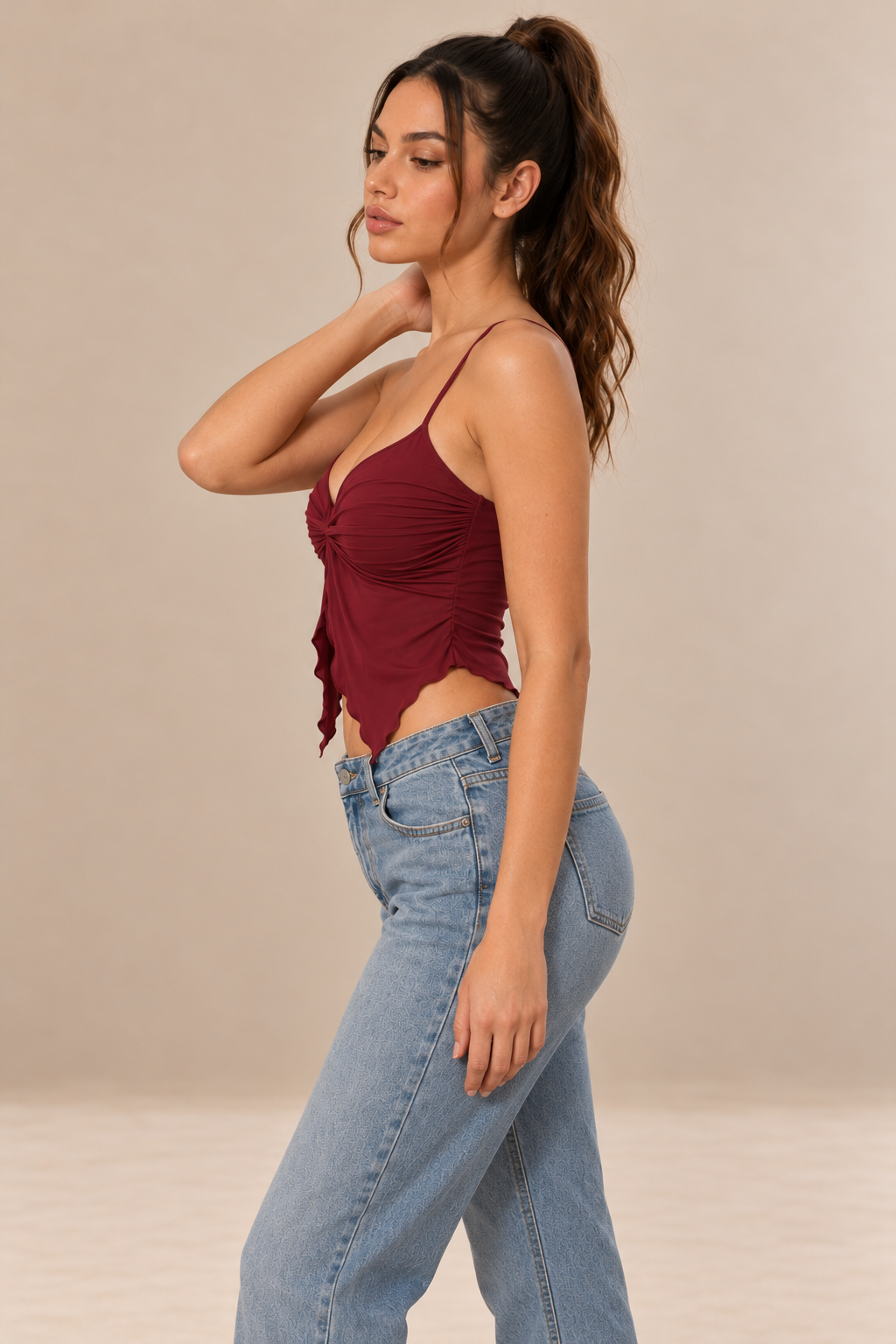 Nora women's twist front cami top in claret, shown in profile with slender straps, a V-neckline, gathered fabric and a pointed asymmetric hem.